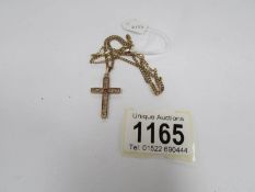 A 9ct gold cross set small ruby on 9ct gold chain