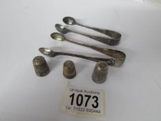 2 silver sugar tongs and 3 silver thimbles,