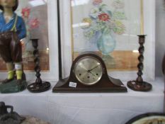 An oak mantel clock and a pair of oak barley twist candlesticks