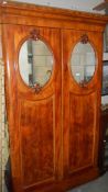 A double wardrobe with oval mirrors in doors