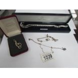 2 silver necklaces, a silver bracelet and a silver clef brooch,