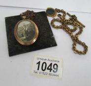 An old photo pendant on chain and a watch chain with fob
