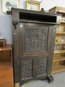 A carved oak drinks cabinet,