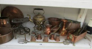 A shelf of assorted brass and copper including kettle with burner and trivet, measures etc.