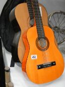 An acoustic guitar and a child's acoustic guitar