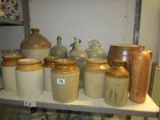 A shelf of stoneware and glass bottles including flaggons, soda syphons etc.