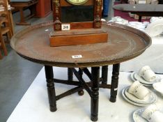 A large brass topped Eastern table with folding base