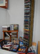 A large quantity of CDs, DVDs, and Blu-Rays and 2 CD shelves.