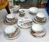 A Japanese porcelain tea set with raised Geisha in cups