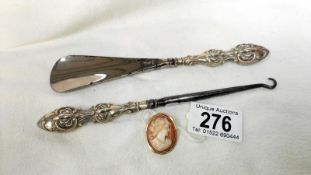 A silver handled shoe horn & button hook & a cameo set in gold marked 750