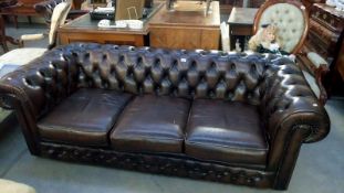 A brown deep buttoned Chesterfield