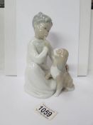 A Lladro figure of a boy with his dog