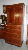A mahogany inlaid linen cupboard upon 2 over 3 chest of drawers