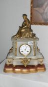 An alabaster mantel clock with gilt ornate figurine decoration