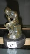 A bronze model of The Thinker on stand