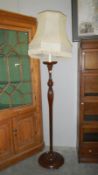 A wooden standard lamp with shade