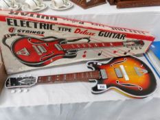 A child's electric type deluxe guitar in original box