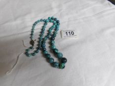 A necklace of turquoise graduated beads with silver clasp