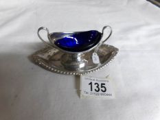 A silver salt with blue glass liner and tray