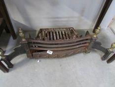 A cast iron fire grate with brass fittings