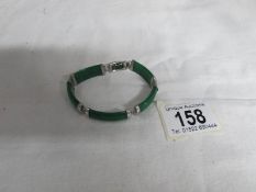 A white metal and jade bracelet