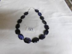 A blue sparkly necklace with silver fittings/clasp