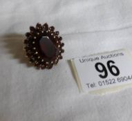 A large 9ct gold garnet set ring with large central garnet,