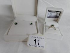 A matching silver ring and earrings set with synthetic emerald