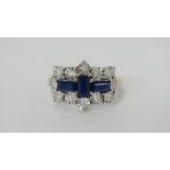 A sapphire and diamond cross shaped gold ring