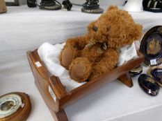 A miniature pine crib with teddy bear