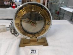 An Art Deco glass and brass clock with electric movement and in working order