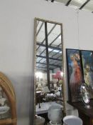 A tall gilt framed mirror