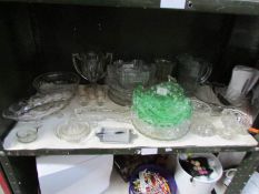 A shelf of glassware including green glass fruit set, vases, bowls etc