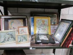 A shelf of framed and glazed prints etc