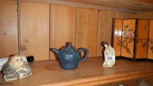 A Chinese Buddha, another Chinese figure, a Chinese teapot, table screen and scroll