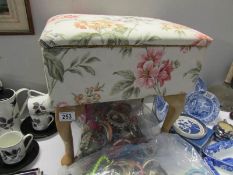 A floral fabric covered work box with Queen Anne style legs