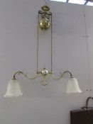 An Edwardian rise and fall brass ceiling light with later shades