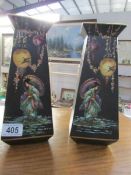 A pair of hand painted vases with oriental scenes