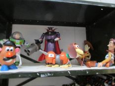 A shelf of Disney toys including Toy Story