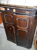 An antique oak corner cupboard