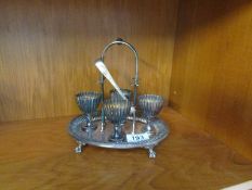 A silver plated egg cup stand with 4 egg cups (missing spoons)
