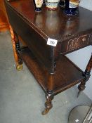 An old drop leaf trolley with drawer