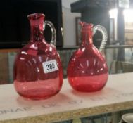 A pair of cranberry decanters