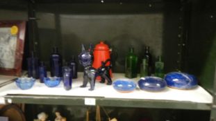 A shelf of glass including old blue and old green medicine bottles