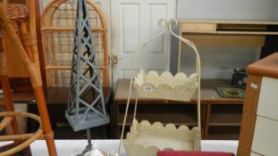 A two tier metal stand with leaf effect and a tall polyhedron style candle holder