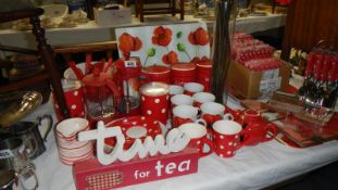 A large quantity of red and white kitchenware