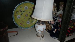 A large Chinese plate and a table lamp