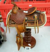 A miniature ornamental saddle on stand