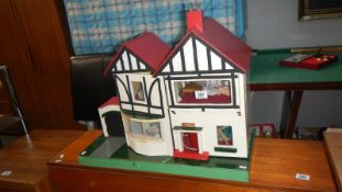 A child's dolls house with contents