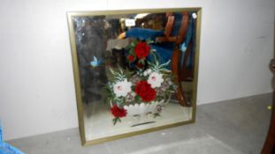 A framed mirror with floral decoration